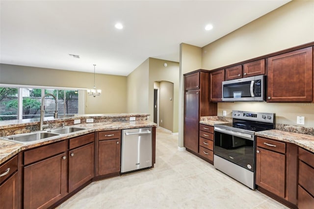 kitchen featuring light stone counters, sink, a chandelier, and appliances with stainless steel finishes