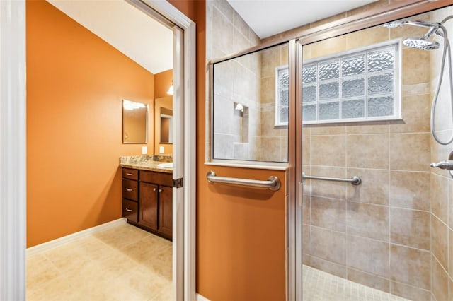 bathroom with tile patterned floors, vanity, vaulted ceiling, and a shower with door