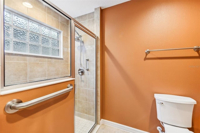 bathroom featuring toilet and a shower with door