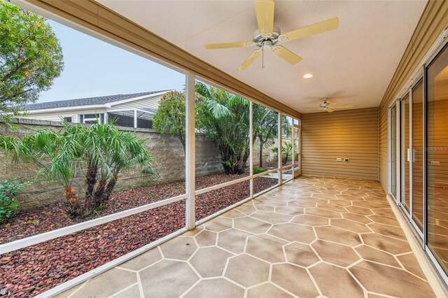 unfurnished sunroom featuring ceiling fan