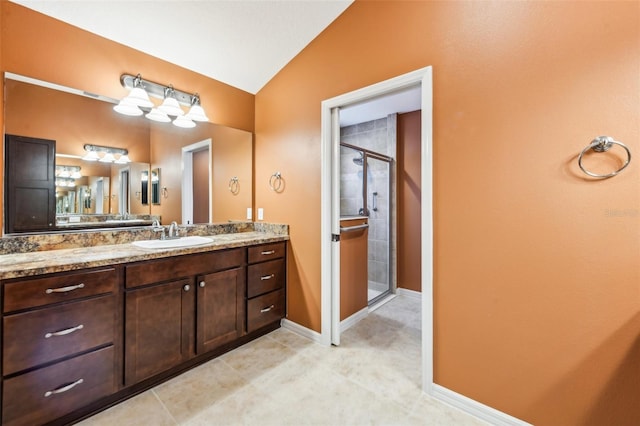 bathroom featuring tile patterned floors, vanity, lofted ceiling, and walk in shower