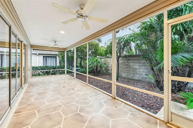 unfurnished sunroom featuring ceiling fan