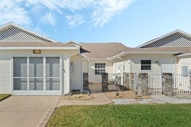 view of front facade with a front lawn and a sunroom