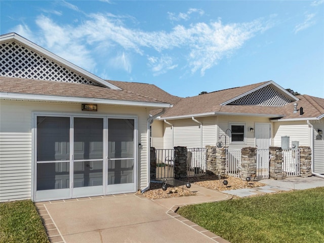 rear view of house with a yard and a sunroom