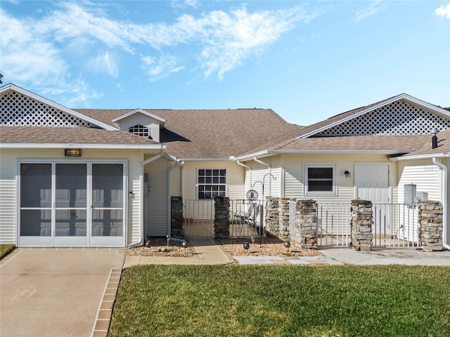 view of front of home featuring a front yard and a sunroom