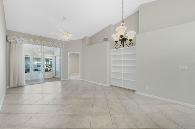 tiled empty room with high vaulted ceiling and ceiling fan with notable chandelier