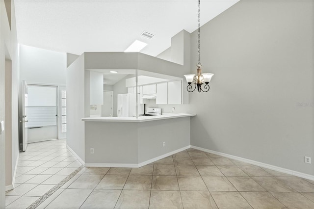 kitchen featuring white appliances, white cabinets, hanging light fixtures, light tile patterned floors, and kitchen peninsula