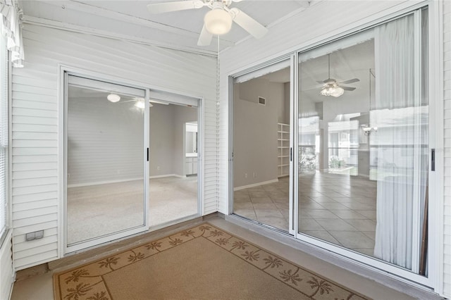 unfurnished sunroom featuring ceiling fan