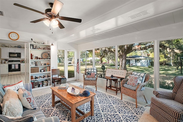 sunroom / solarium featuring beam ceiling and ceiling fan