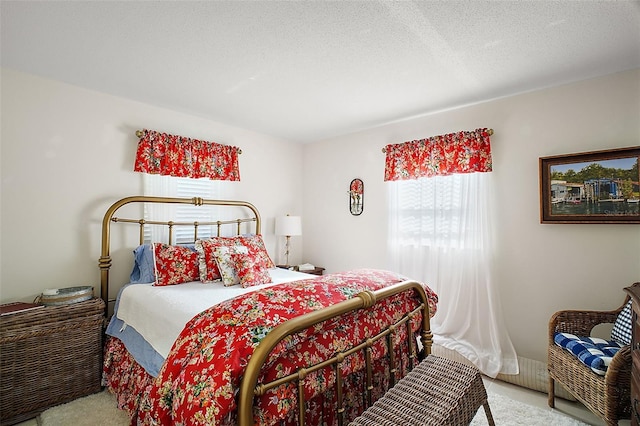 bedroom featuring light colored carpet and a textured ceiling