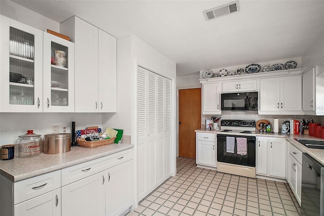 kitchen with white range with electric stovetop, dishwasher, white cabinetry, and light tile patterned floors