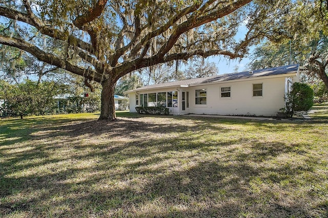 back of property featuring a lawn