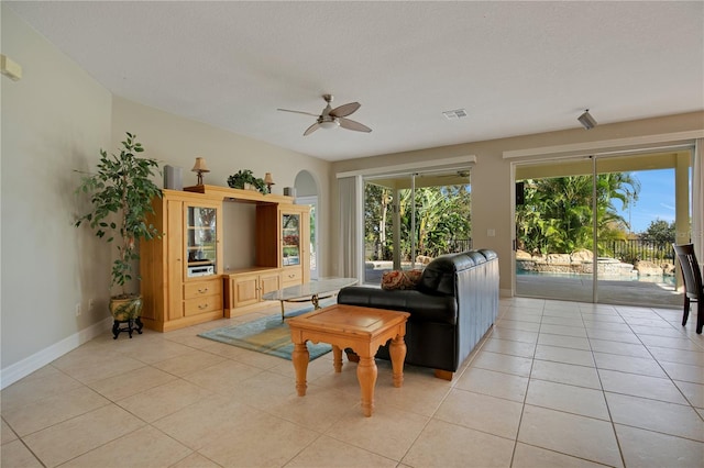 living room with ceiling fan, light tile patterned floors, and a healthy amount of sunlight