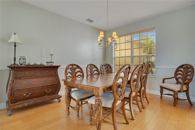 dining area with a chandelier and light hardwood / wood-style flooring