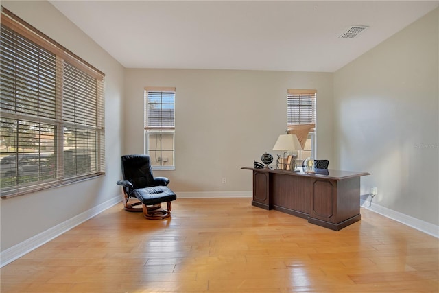 home office with a healthy amount of sunlight and light wood-type flooring