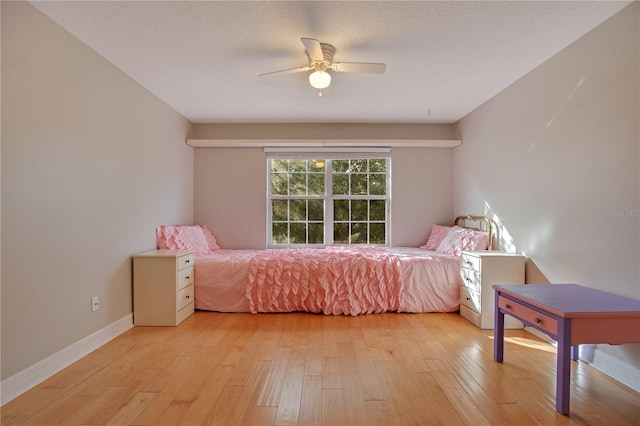 bedroom with ceiling fan, a textured ceiling, and light hardwood / wood-style flooring