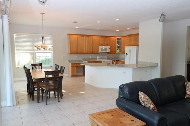 kitchen with decorative light fixtures, light stone countertops, white appliances, and light tile patterned floors