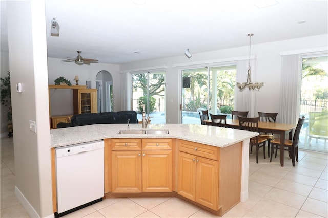 kitchen with light stone countertops, ceiling fan with notable chandelier, sink, dishwasher, and light tile patterned flooring