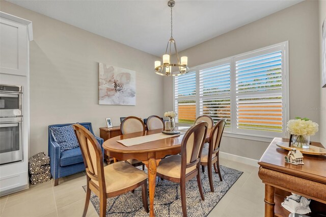 tiled dining room featuring a healthy amount of sunlight and an inviting chandelier