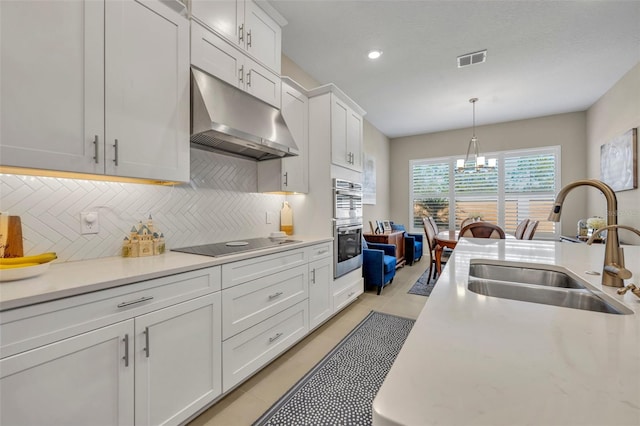 kitchen with white cabinetry, sink, decorative light fixtures, black electric stovetop, and light tile patterned floors