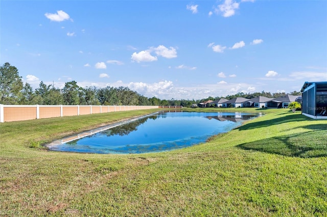 view of pool with a lawn and a water view