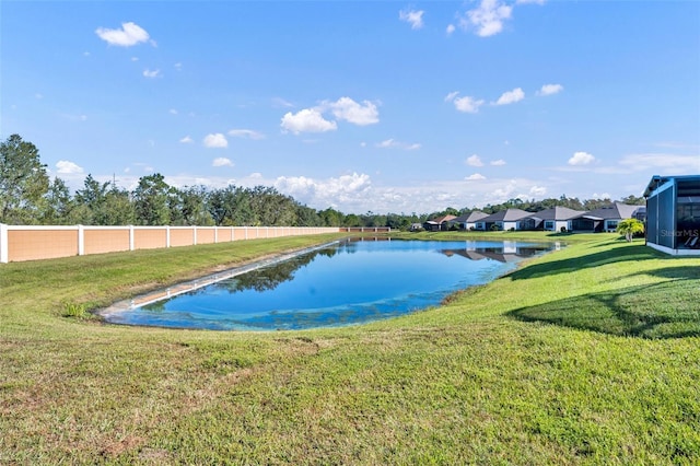 view of pool with a water view and a yard