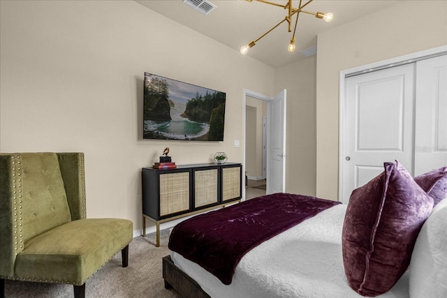 carpeted bedroom featuring a closet and a notable chandelier