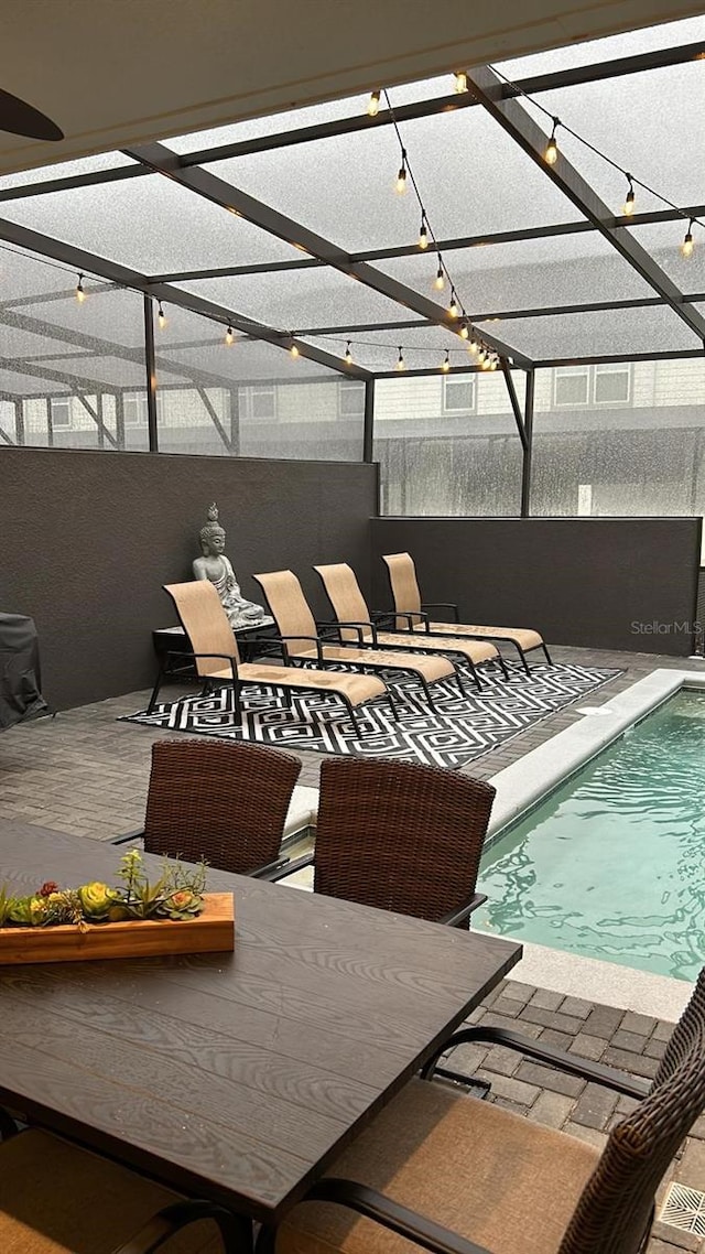 view of swimming pool featuring a patio area and glass enclosure