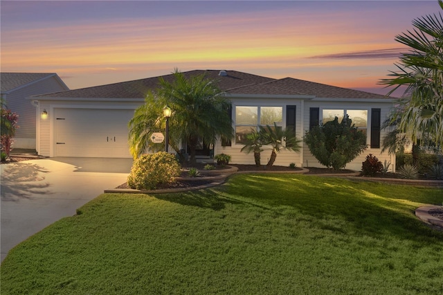 view of front of house featuring a garage and a yard