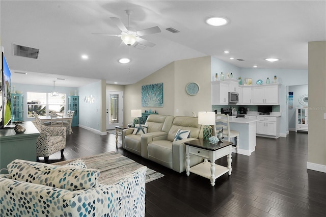 living room featuring dark hardwood / wood-style flooring, vaulted ceiling, and ceiling fan