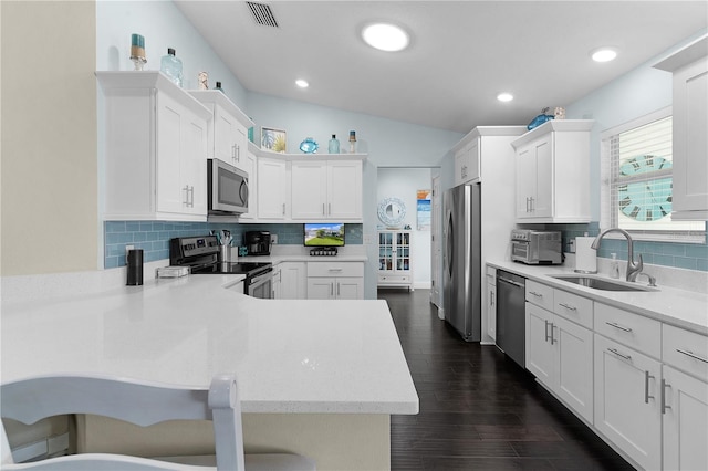 kitchen featuring kitchen peninsula, appliances with stainless steel finishes, white cabinetry, and sink