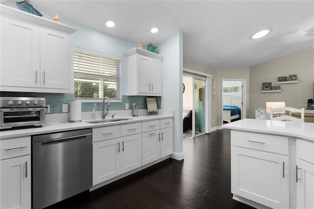 kitchen with backsplash, stainless steel dishwasher, sink, dark hardwood / wood-style floors, and white cabinetry