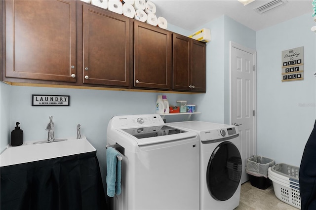 laundry area featuring washing machine and clothes dryer and cabinets