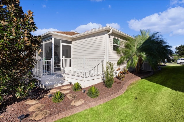 view of property exterior featuring a yard and a sunroom