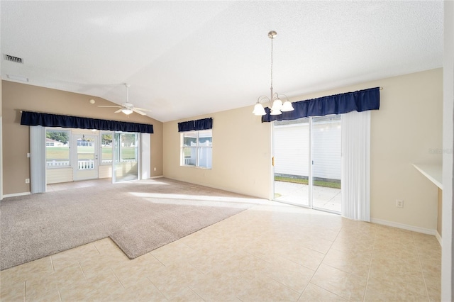 empty room featuring light tile patterned floors, ceiling fan with notable chandelier, a textured ceiling, and lofted ceiling