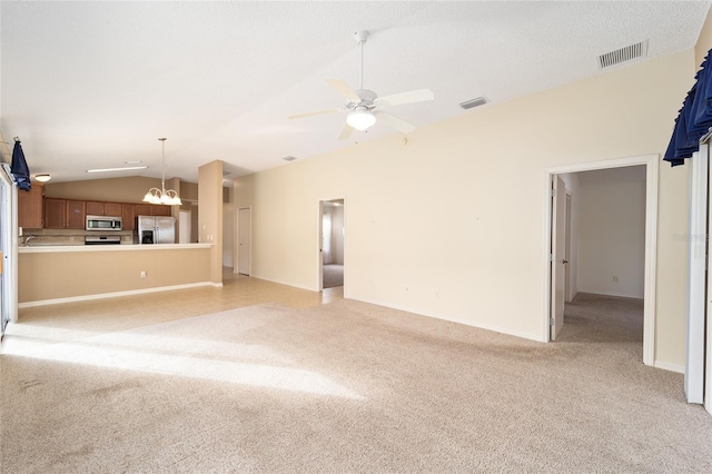 unfurnished living room with ceiling fan with notable chandelier, light colored carpet, and lofted ceiling