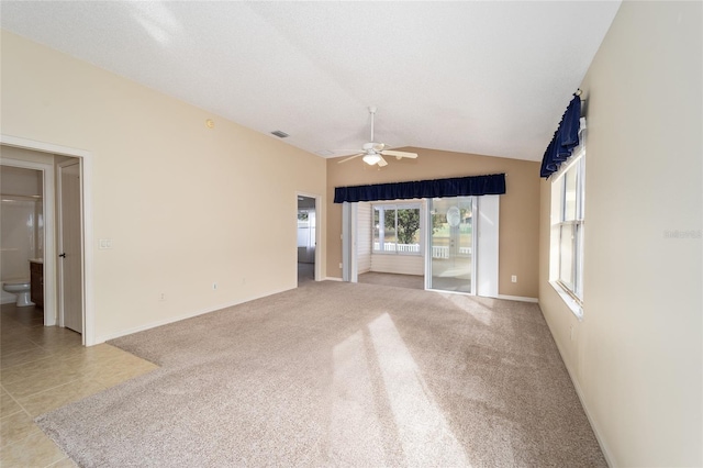 unfurnished living room featuring ceiling fan, light colored carpet, and vaulted ceiling