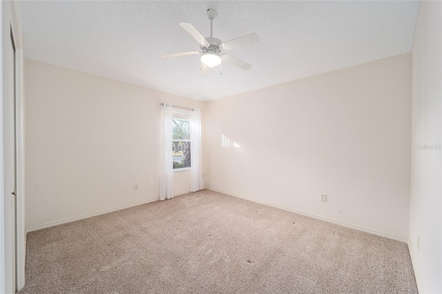 empty room with a textured ceiling, light colored carpet, and ceiling fan