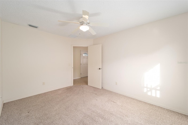 empty room featuring light carpet, a textured ceiling, and ceiling fan