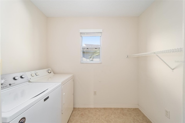 clothes washing area featuring independent washer and dryer, a textured ceiling, and light tile patterned floors