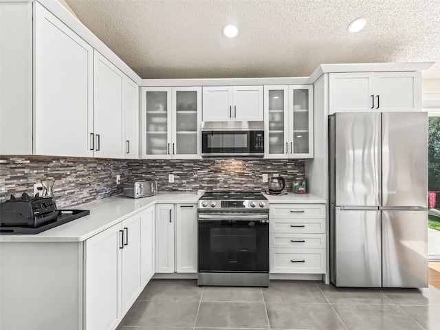 kitchen with white cabinets, stainless steel appliances, and a textured ceiling