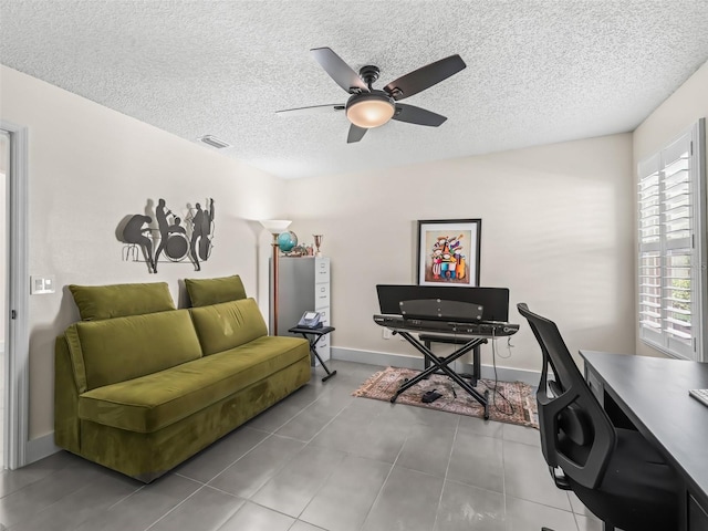 office featuring ceiling fan, light tile patterned flooring, and a textured ceiling