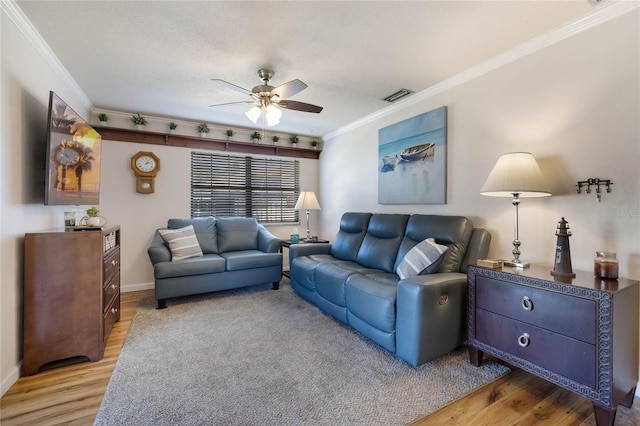 living room with light wood-type flooring, ceiling fan, and ornamental molding