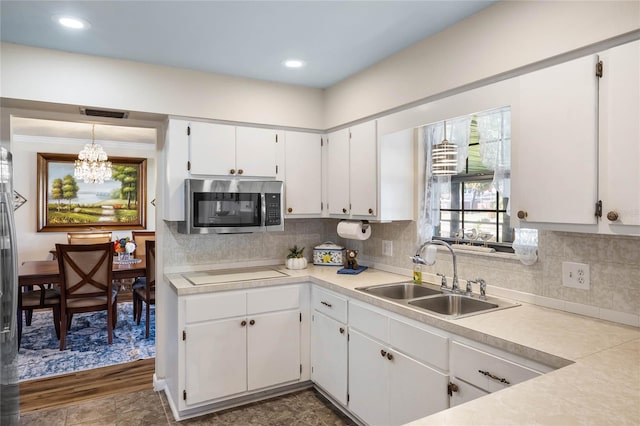 kitchen featuring sink, decorative light fixtures, an inviting chandelier, white cabinets, and dark hardwood / wood-style floors