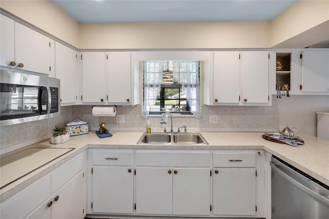 kitchen featuring decorative backsplash, white cabinetry, sink, and appliances with stainless steel finishes