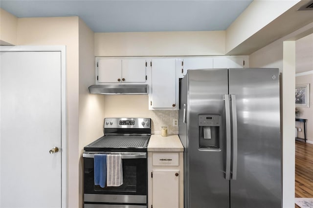 kitchen with white cabinets, appliances with stainless steel finishes, tasteful backsplash, and hardwood / wood-style floors