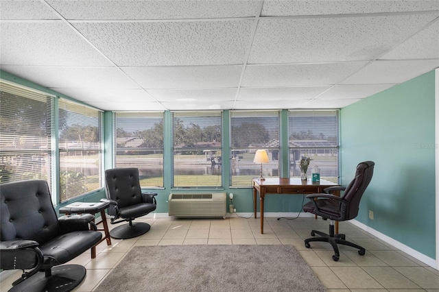 home office featuring a wall mounted air conditioner, a drop ceiling, and light tile patterned flooring