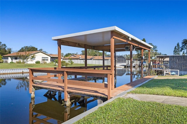 view of dock featuring a lawn and a water view