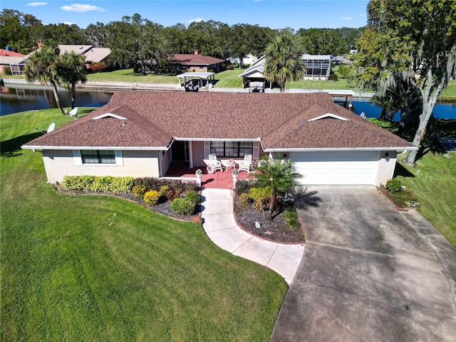 ranch-style home with a garage, a water view, and a front lawn