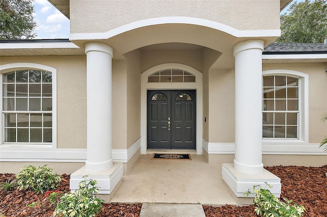 14701 Timucua Pl, Clermont, FL 34711 - view of exterior entry featuring stucco siding and roof with shingles